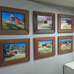 A photo of 6 oil paintings of covered bridges in Madison County, Iowa.